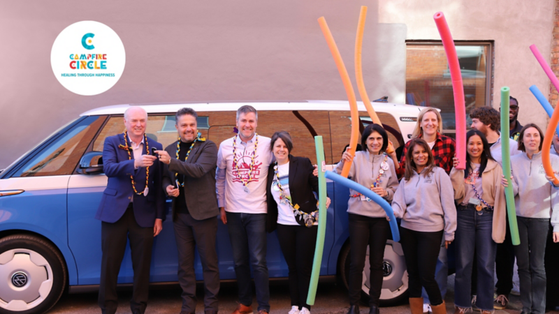 VW remet avec joie les clés au gagnant de la vente aux enchères ID.Buzz avec le personnel de Campfire Circle